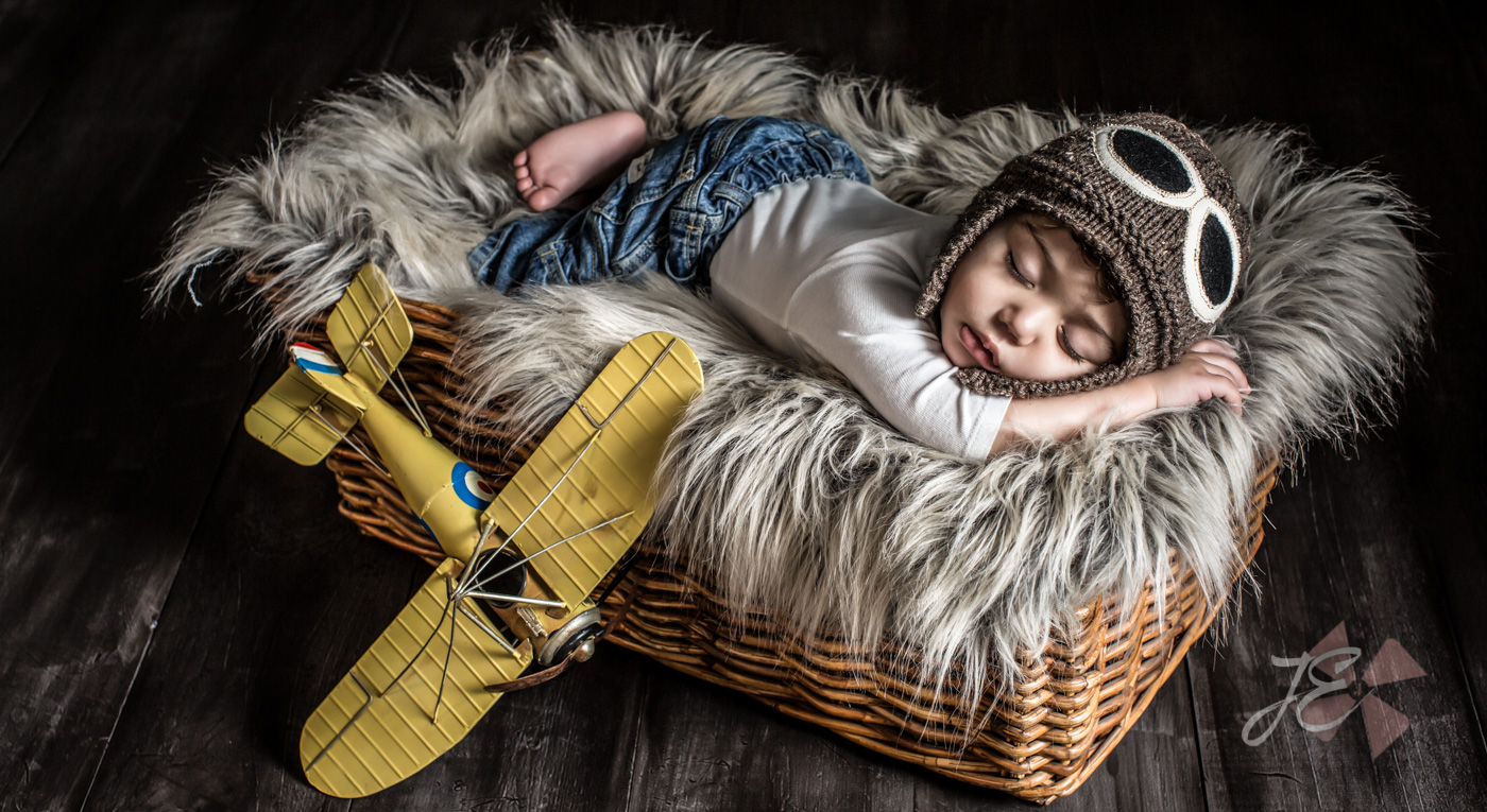 Whimsical Newborn Portrait of a baby boy pilot with his yellow toy airplane