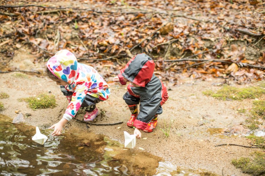 Little kids playing with paper boats